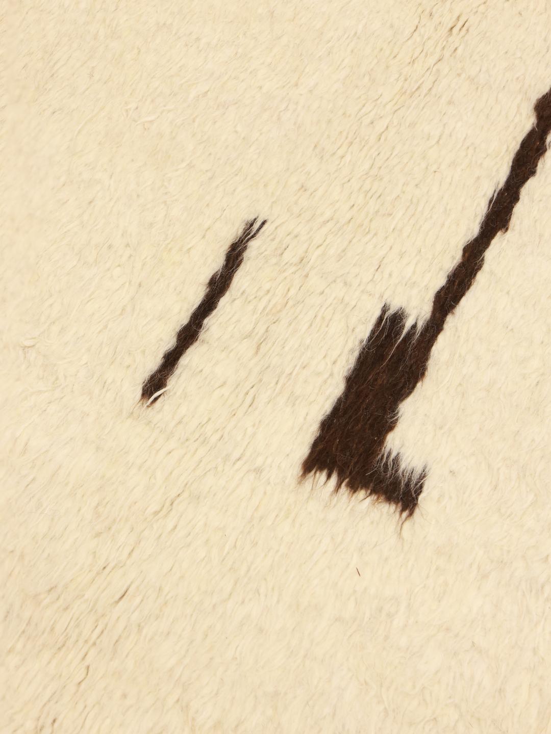 Tapis afghan noué à la main avec un motif géométrique minimaliste en beige et noir.