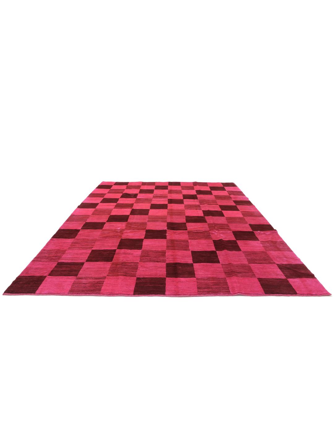 Et håndknyttet Gabbeh tæppe fra Mellemøsten med et levende skakternet mønster i pink og brun.