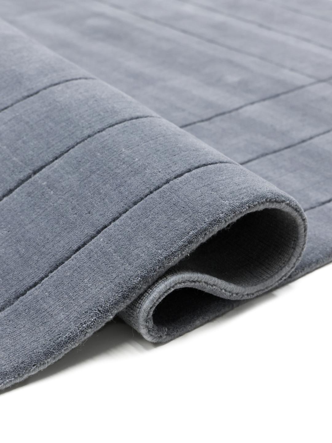 Een zacht blauw tapijt met een decoratieve rand.