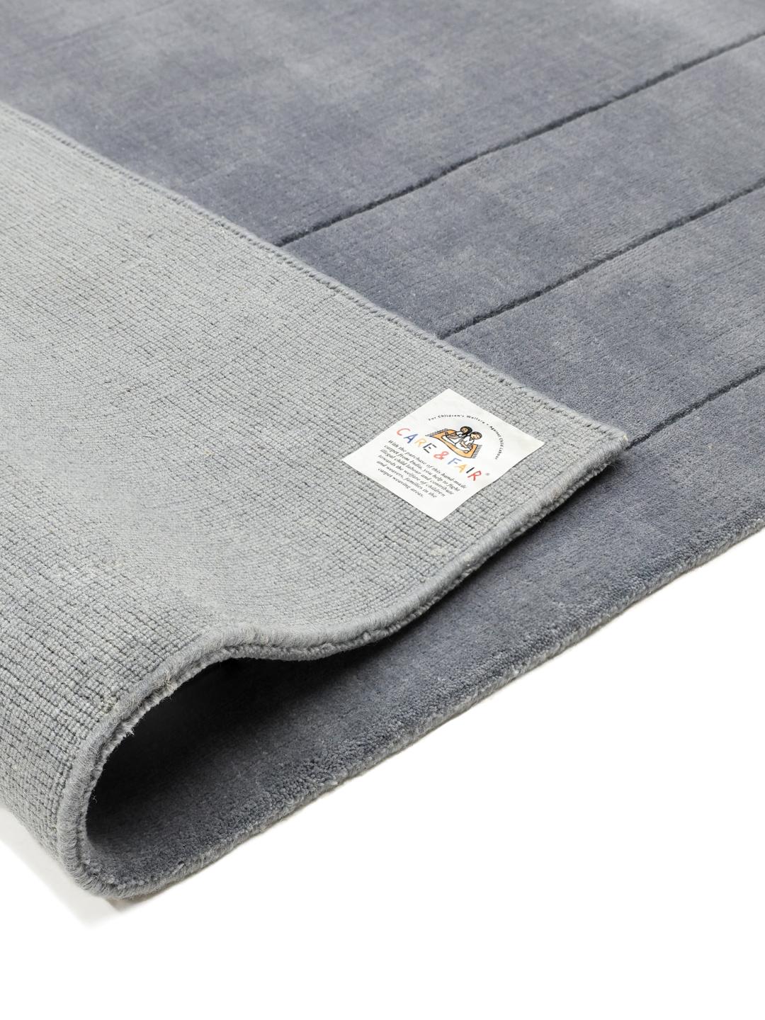 Een zacht blauw tapijt met een decoratieve rand.