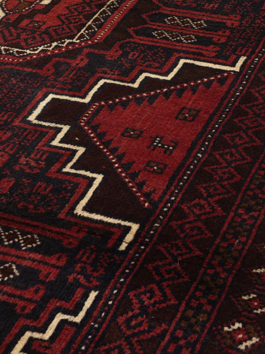 Handgeknoopt tapijt uit het Midden-Oosten in donkerrood met geometrische medaillonpatronen