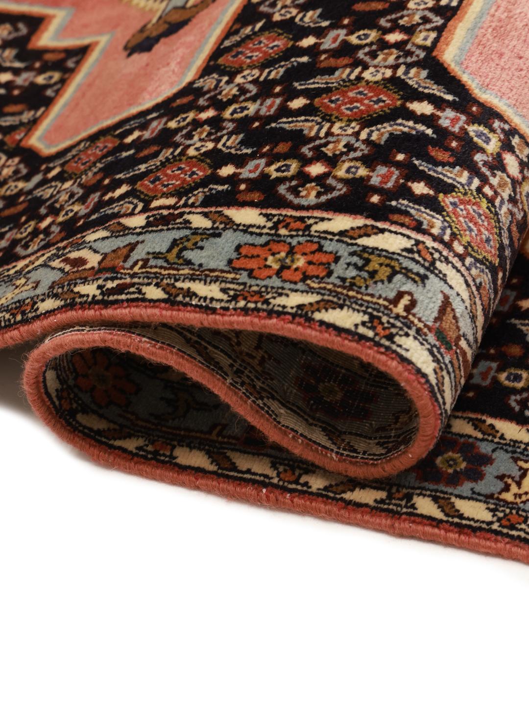 A hand-knotted Senneh runner with a multicolored diamond pattern on a dark field.