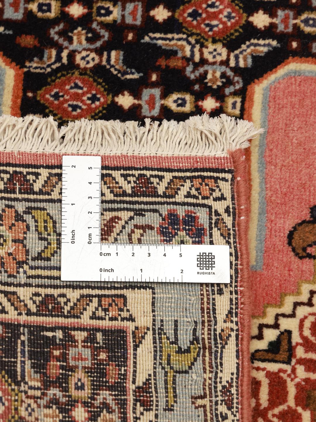 A hand-knotted Senneh runner with a multicolored diamond pattern on a dark field.