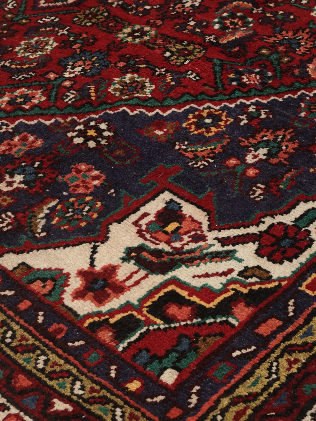 Hand-knotted Hosseinabad rug from the Middle East in deep red and blue tones