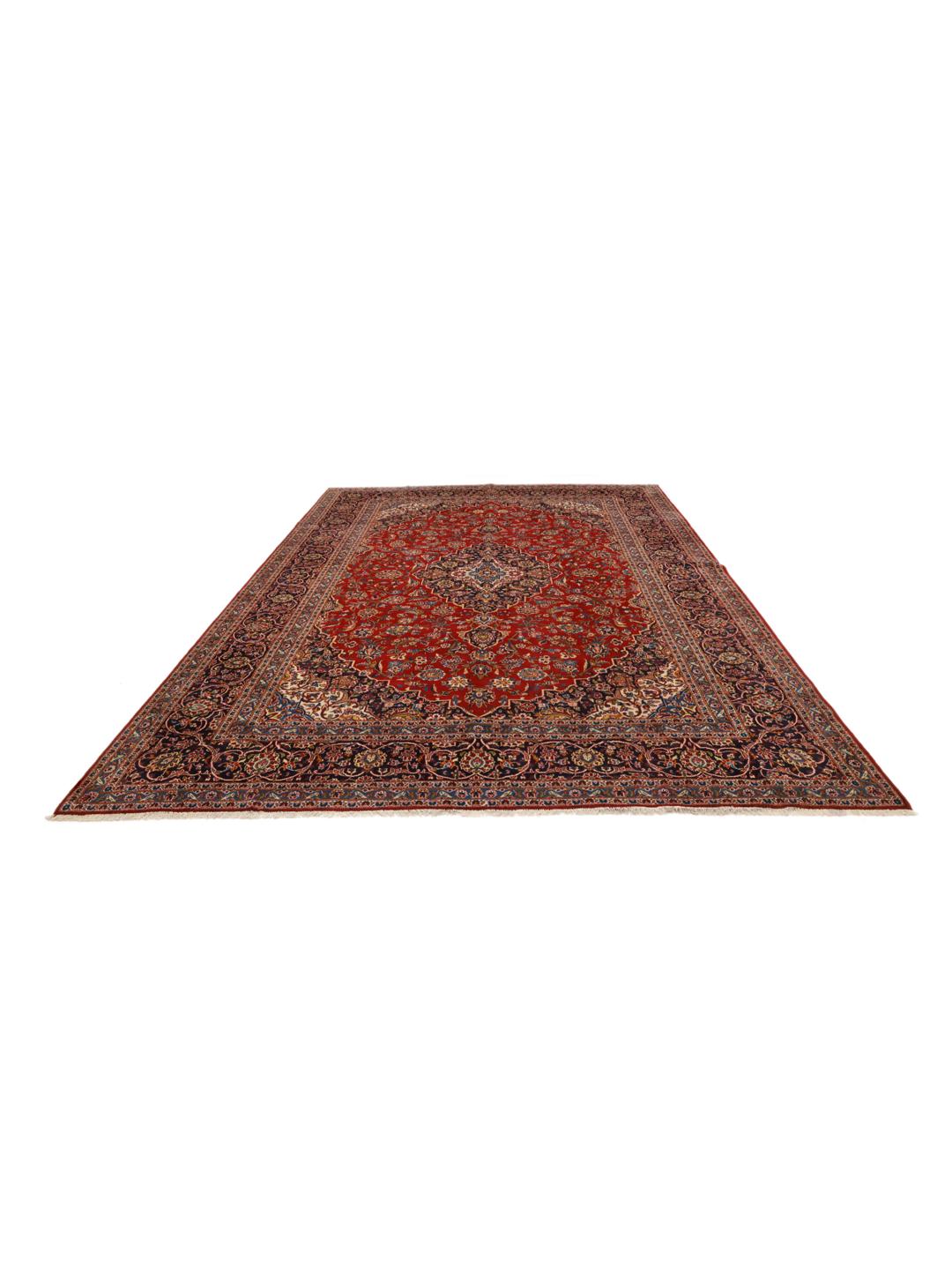 A large, hand-knotted Keshan rug from the Middle East with a red field and ornate floral patterns.