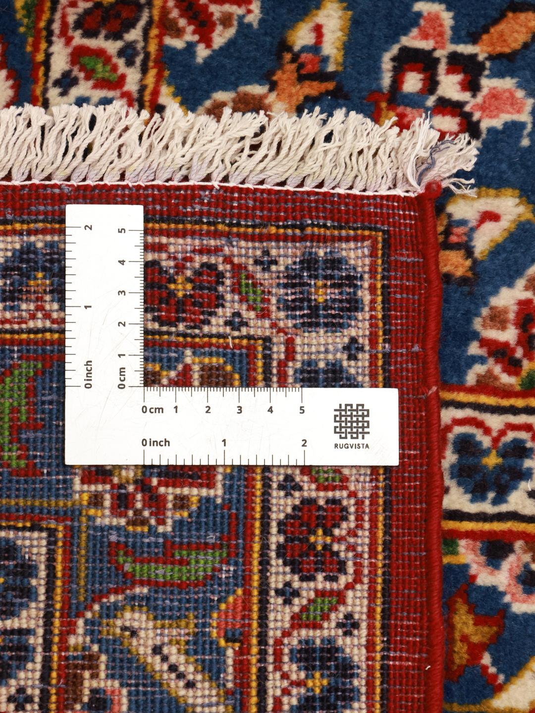 A large, hand-knotted Keshan rug from the Middle East with a red field and ornate floral patterns.