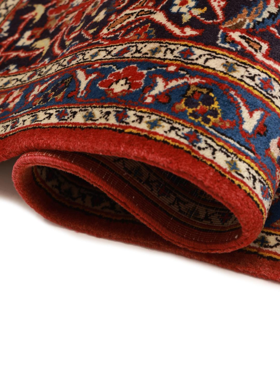 Hand-knotted Keshan rug from the Middle East in red and deep blue tones.