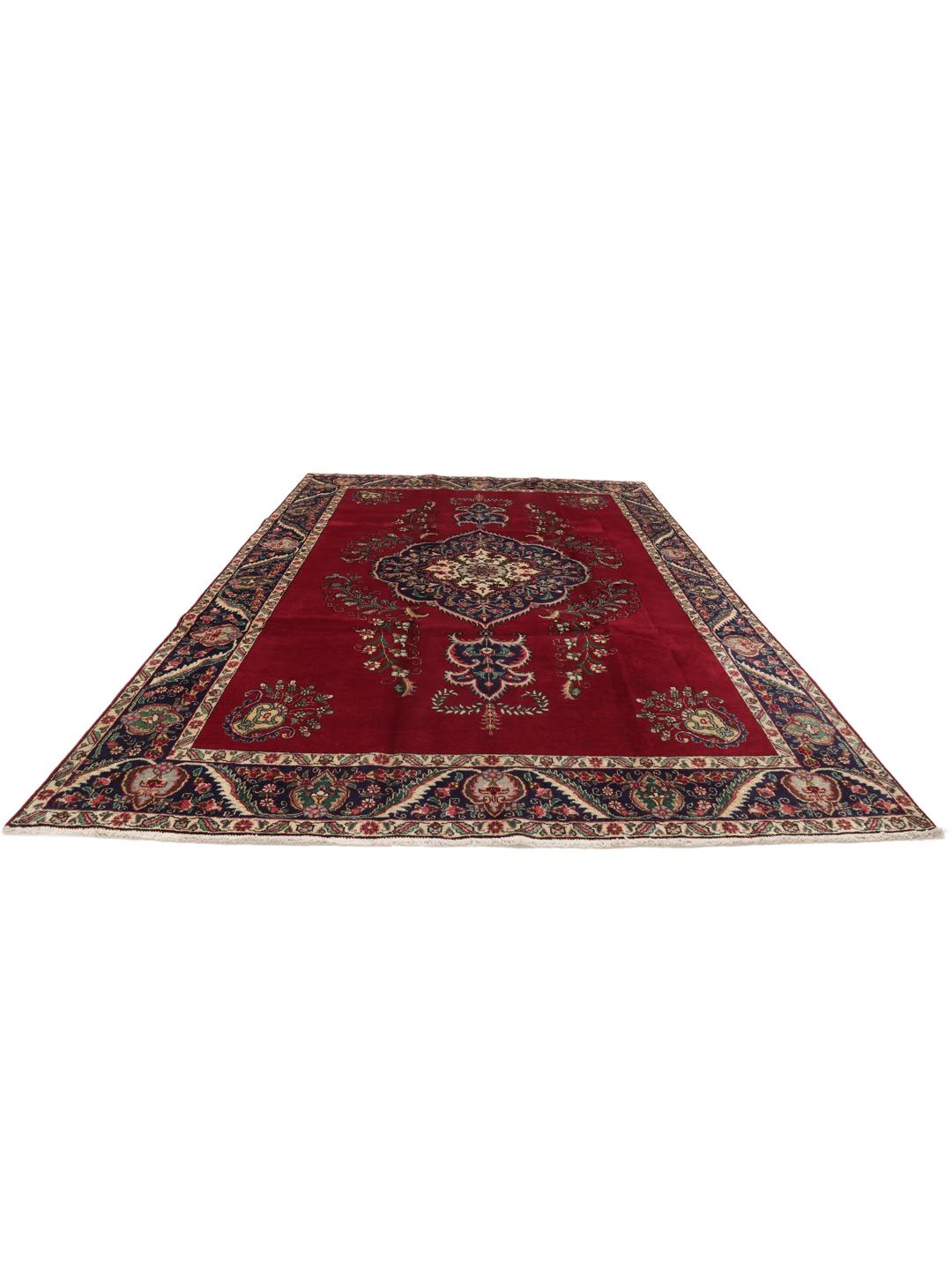 Handmade Tabriz rug with a red field and intricate blue floral medallion from the Middle East