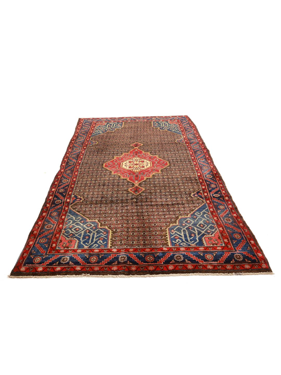 Een handgeknoopt Koliai tapijt met ingewikkelde geometrische motieven in diepblauw, rood en bruin.