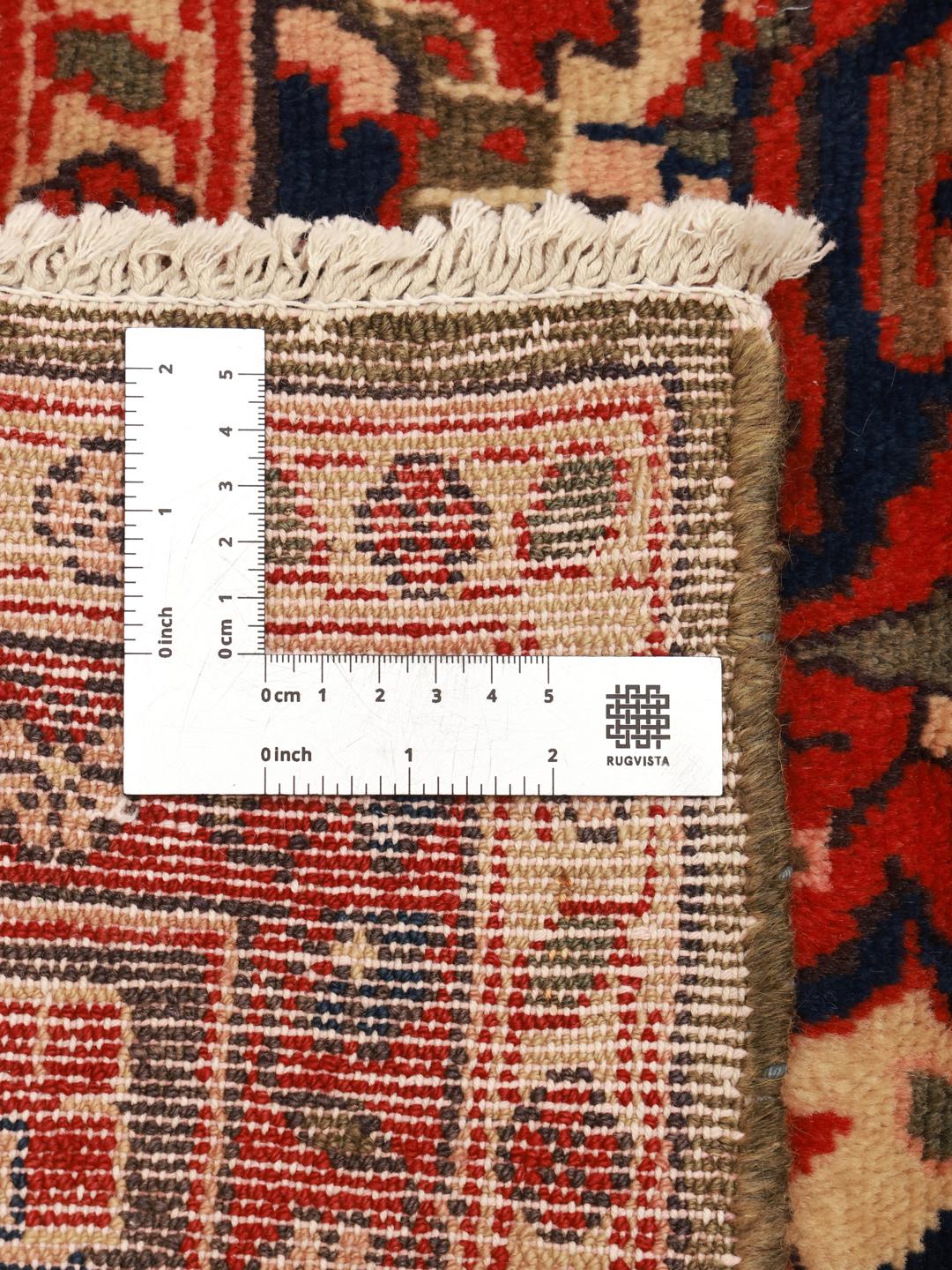 Een handgeknoopt Koliai-tapijt uit het Midden-Oosten in dieprode en beige tinten.