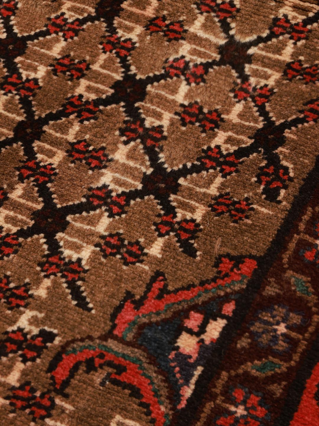 A unique hand-knotted Koliai rug from the Middle East in brown and red tones.