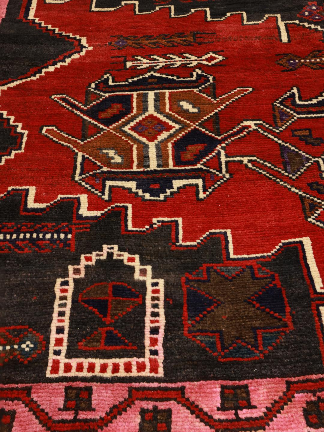 Een uniek Zanjan-tapijt uit het Midden-Oosten met gedurfde rode en zwarte geometrische patronen.