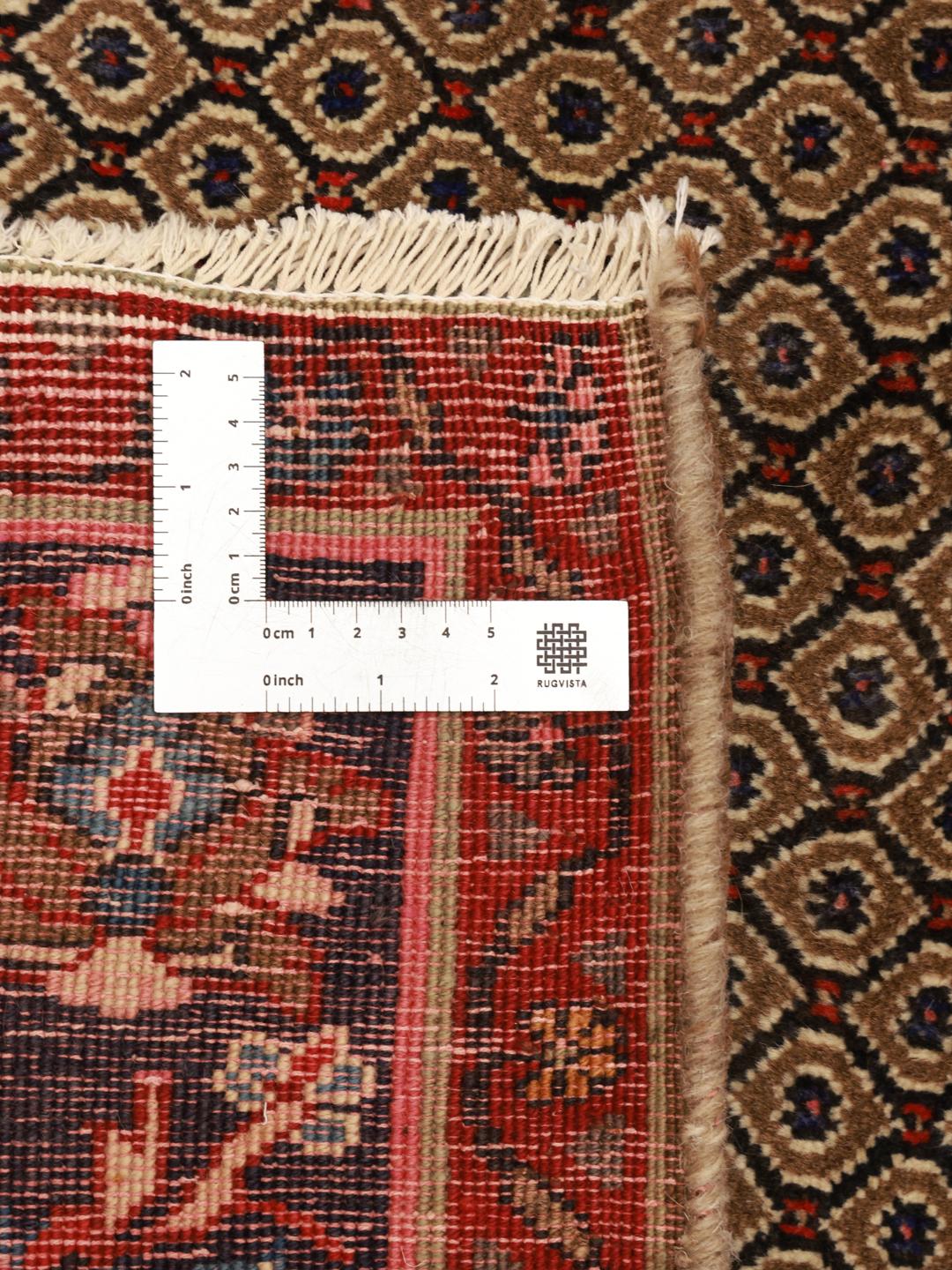 Handgeknoopt Koliai-tapijt uit het Midden-Oosten in bruin met rode en blauwe accenten.