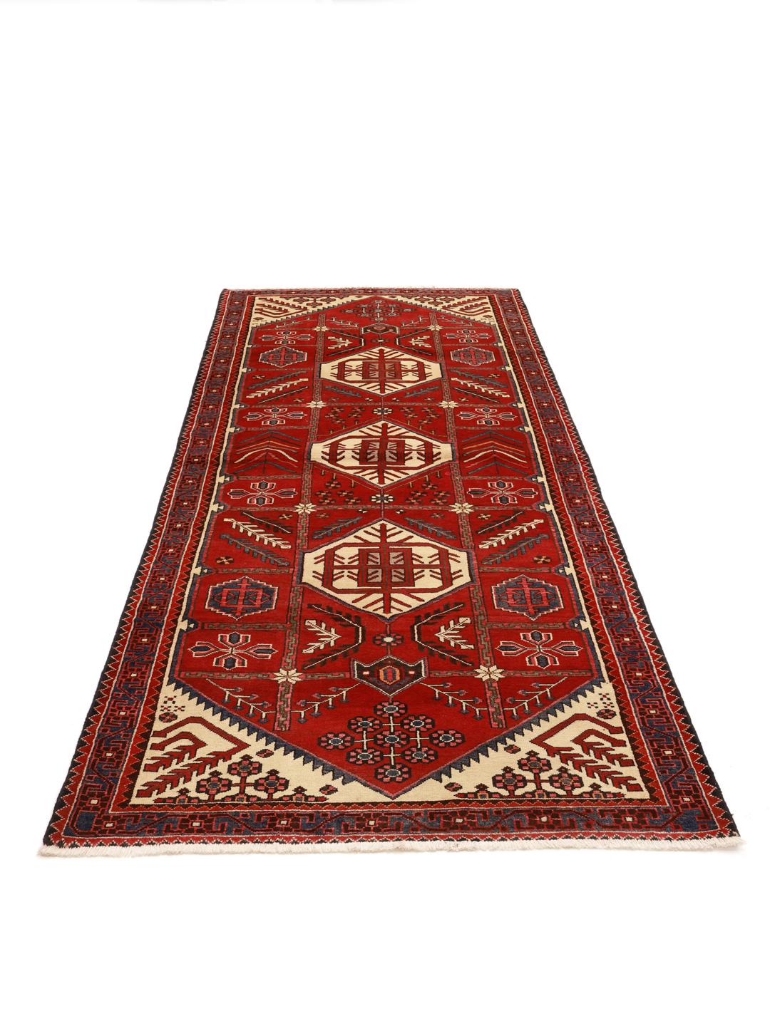 Un tapis couloir Ardebil noué à la main provenant du Moyen-Orient, présentant un champ en laine rouge éclatante avec des motifs géométriques.