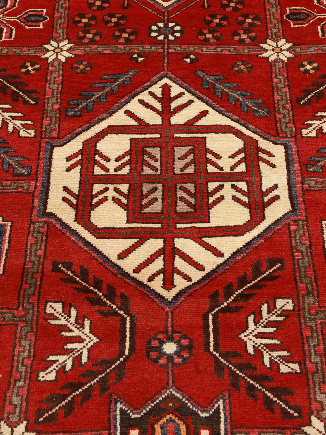 Un tapis couloir Ardebil noué à la main provenant du Moyen-Orient, présentant un champ en laine rouge éclatante avec des motifs géométriques.