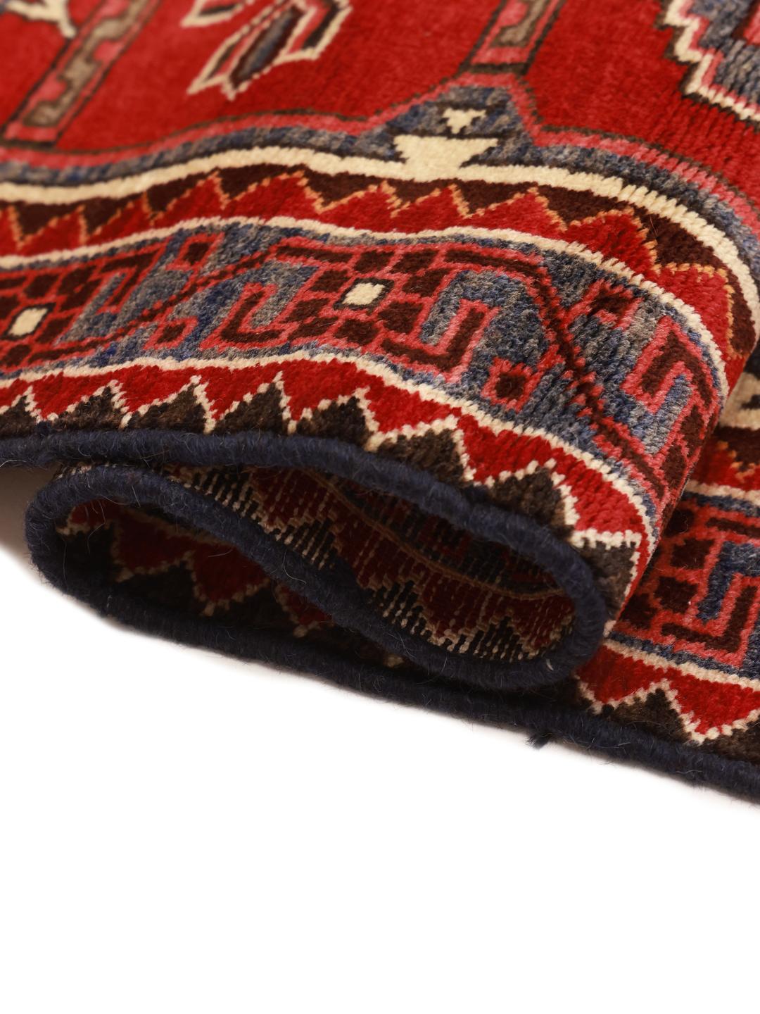 Un tapis couloir Ardebil noué à la main provenant du Moyen-Orient, présentant un champ en laine rouge éclatante avec des motifs géométriques.