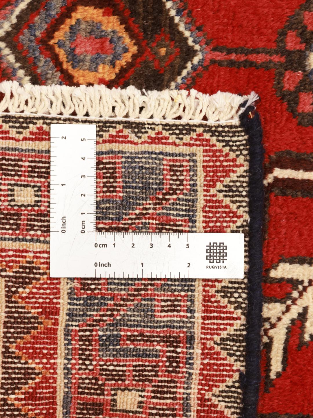 Un tapis couloir Ardebil noué à la main provenant du Moyen-Orient, présentant un champ en laine rouge éclatante avec des motifs géométriques.