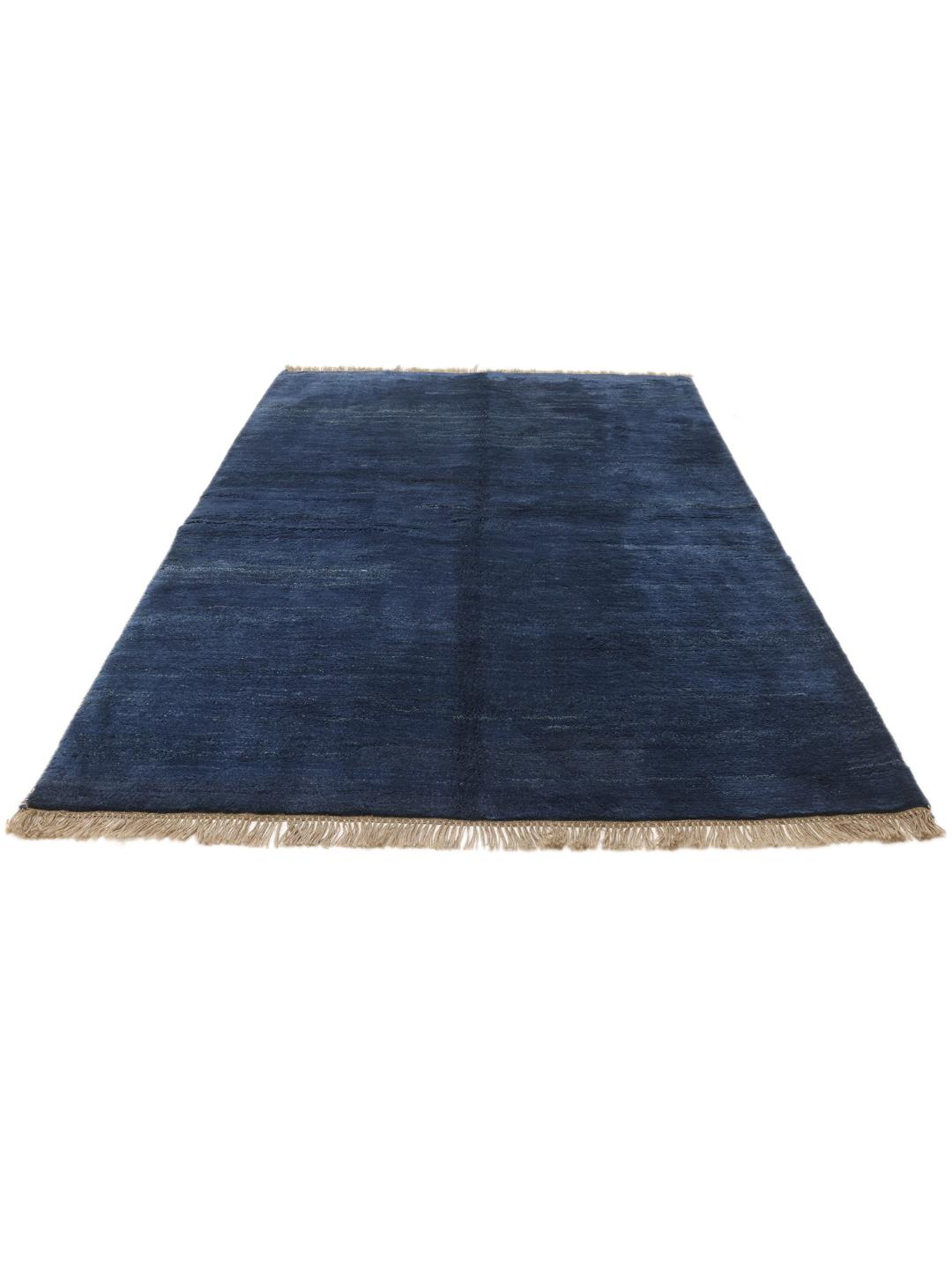 Een diepblauw handgeknoopt Gabbeh-tapijt uit het Midden-Oosten met een zachte wollen textuur.
