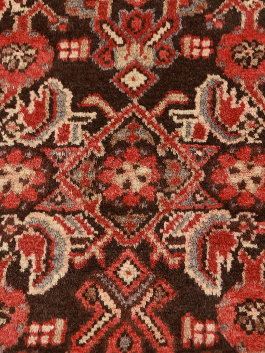 A long, hand-knotted Hamadan runner with a dark-red and cream floral pattern.