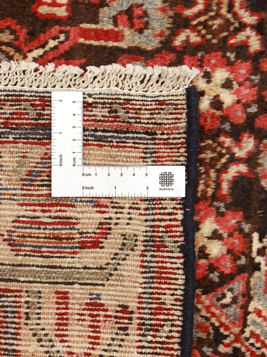 A long, hand-knotted Hamadan runner with a dark-red and cream floral pattern.