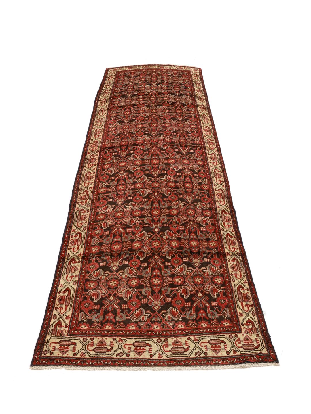 A long, hand-knotted Hamadan runner with a dark-red and cream floral pattern.