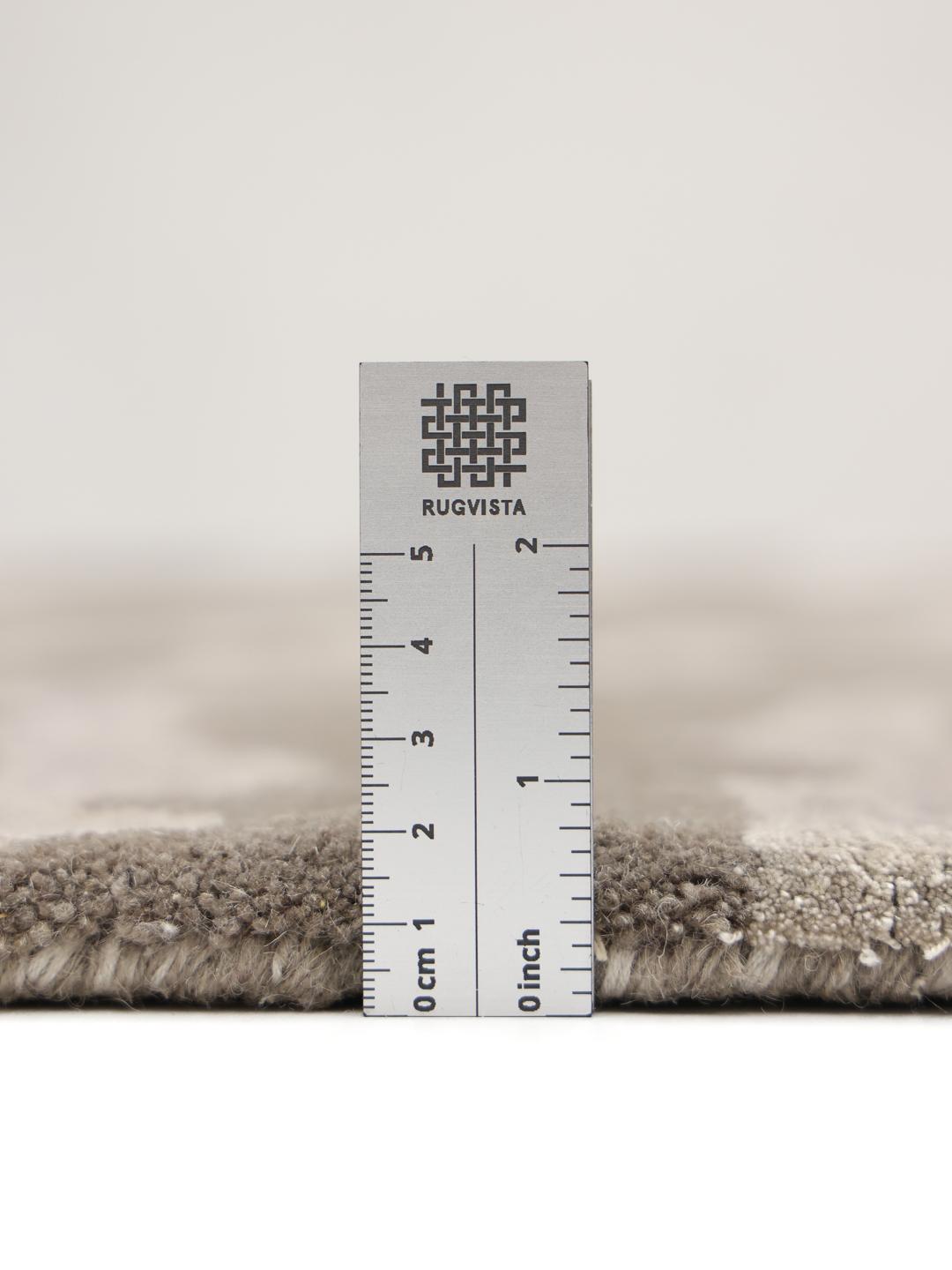 Un tapis rectangulaire avec un motif inspiré des animaux dans des tons grège et gris clair.