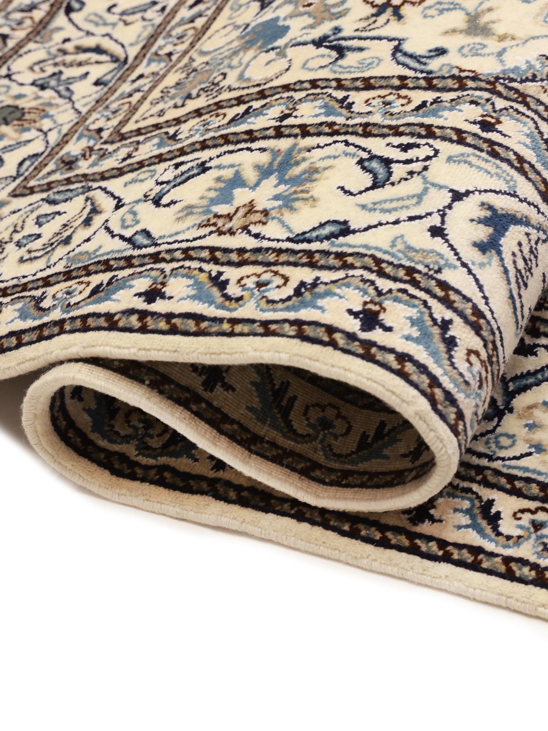 A hand-knotted rug from the Middle East with a dark-blue field and floral patterns.