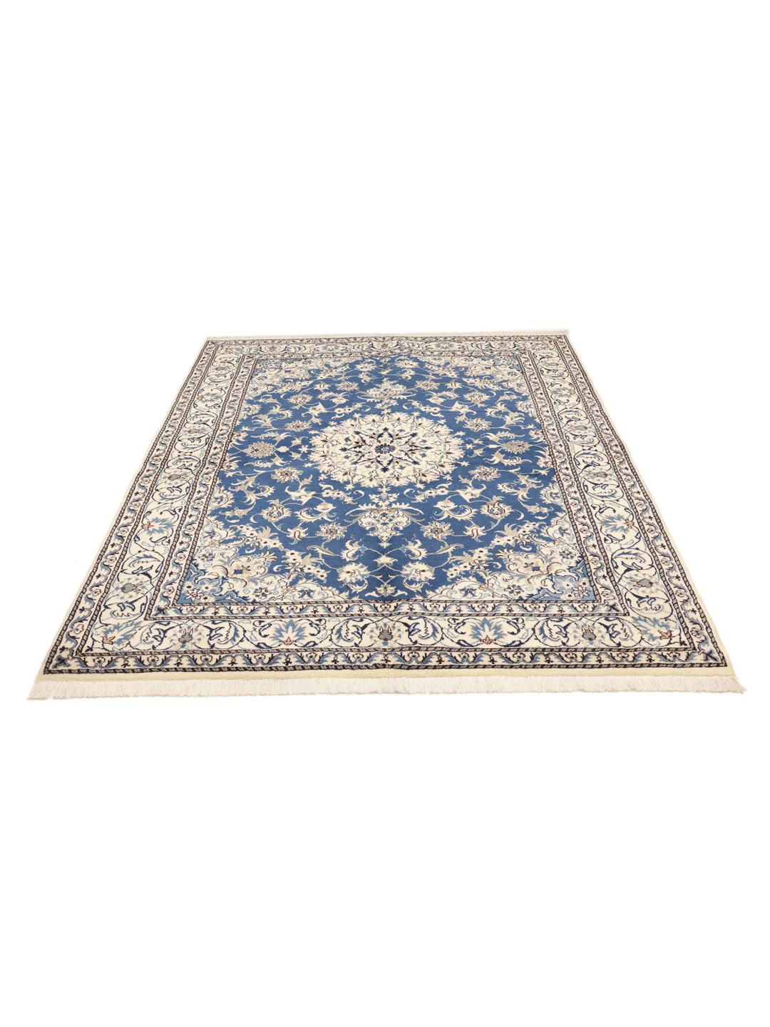 A hand-knotted Nain rug from the Middle East featuring a deep blue field with floral patterns.