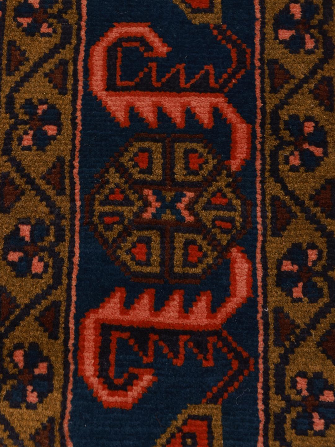 Een handgeknoopt Wiss-tapijt uit het Midden-Oosten met een gedurfd rood en blauw geometrisch patroon.