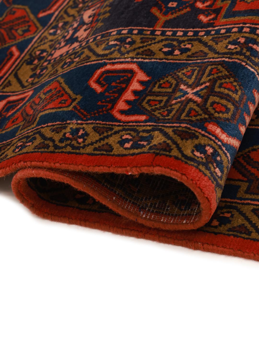 Een handgeknoopt Wiss-tapijt uit het Midden-Oosten met een gedurfd rood en blauw geometrisch patroon.