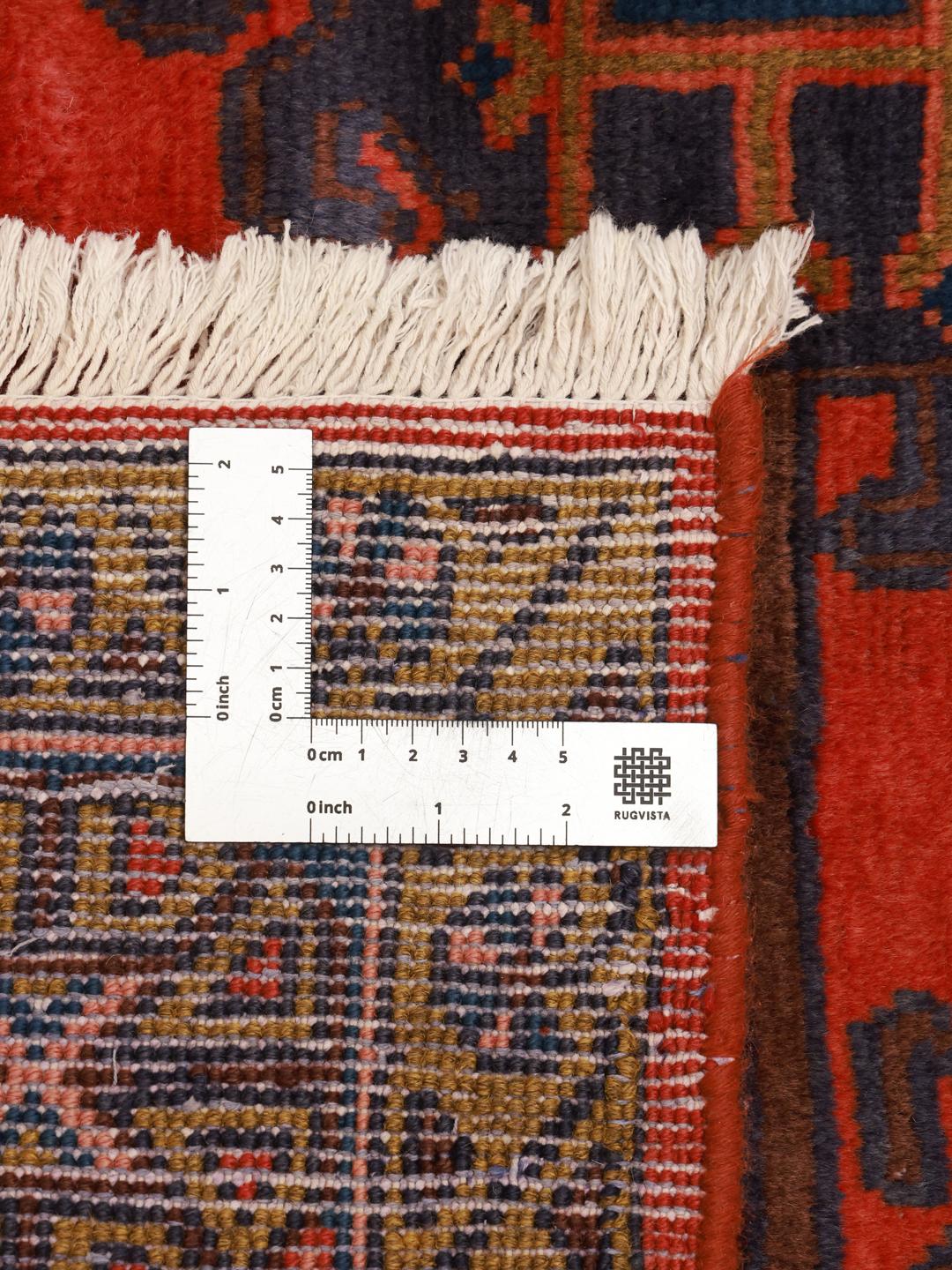 Een handgeknoopt Wiss-tapijt uit het Midden-Oosten met een gedurfd rood en blauw geometrisch patroon.
