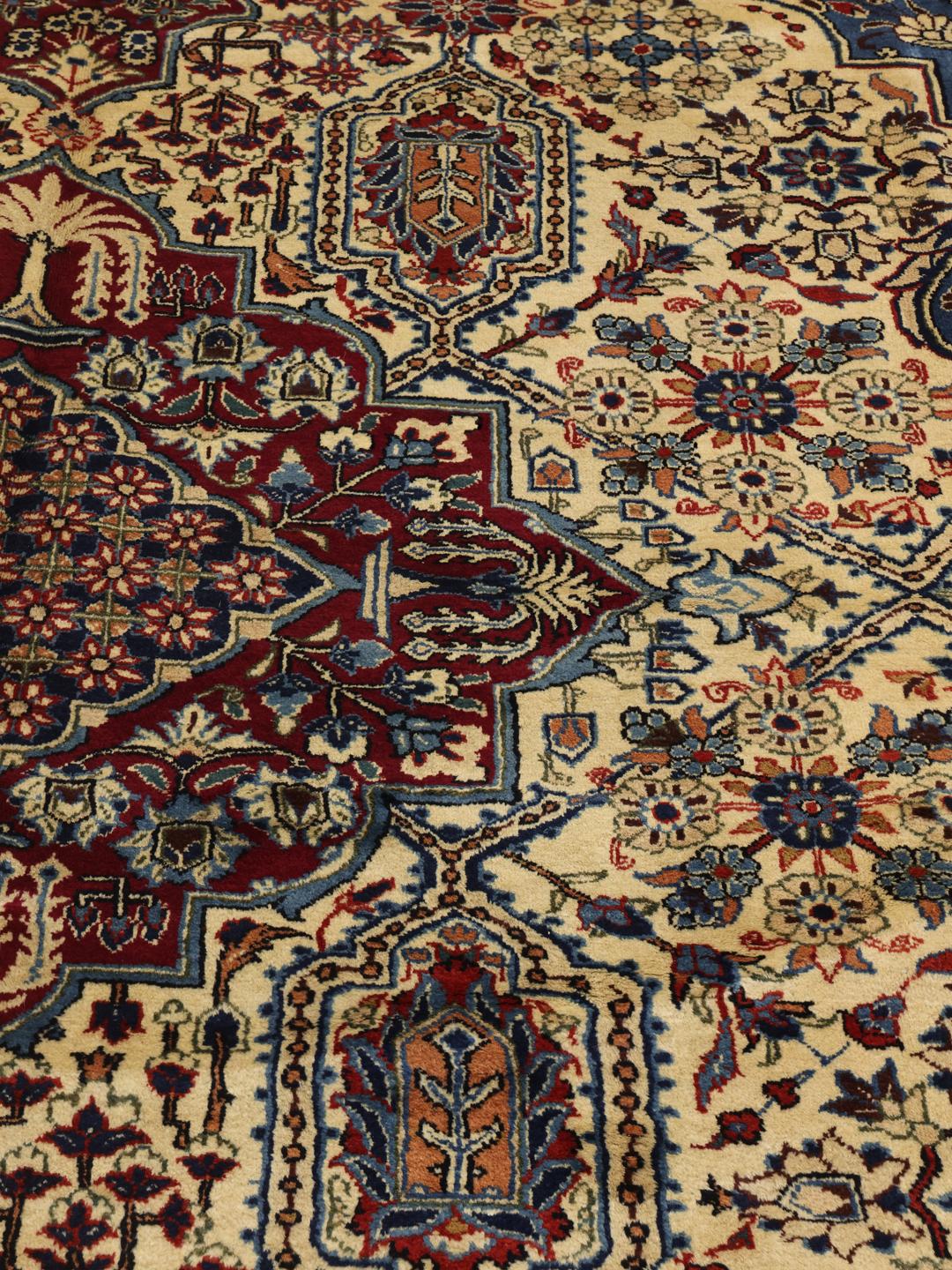 Een groot rechthoekig handgeknoopt Yazd-tapijt uit het Midden-Oosten met een rood en blauw bloemenpatroon.