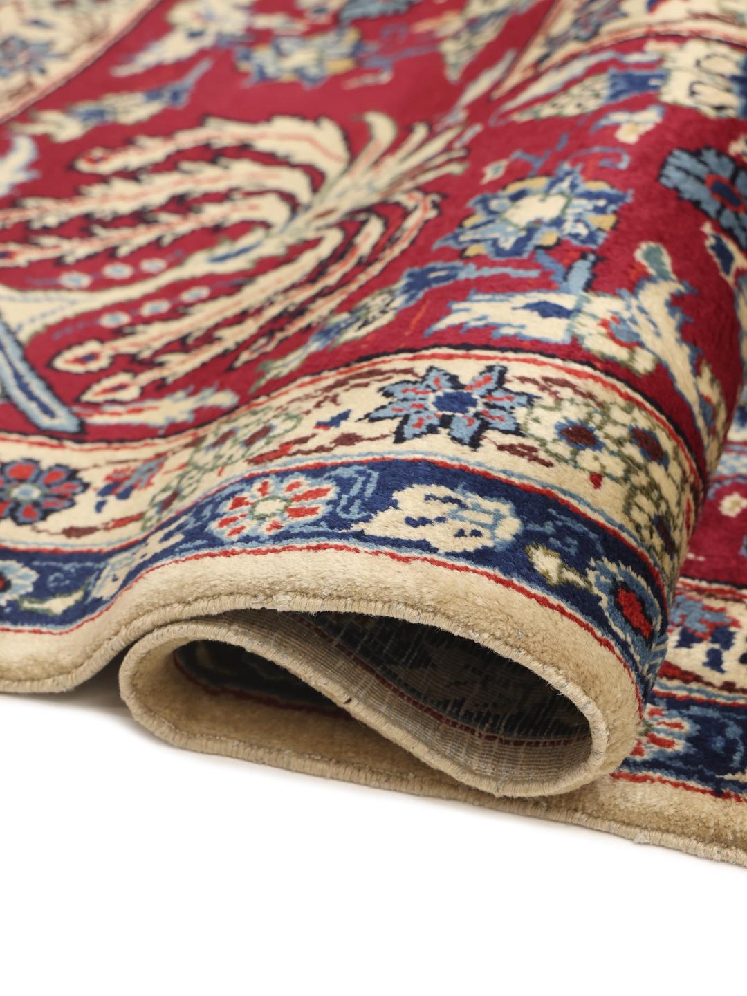 Een groot rechthoekig handgeknoopt Yazd-tapijt uit het Midden-Oosten met een rood en blauw bloemenpatroon.