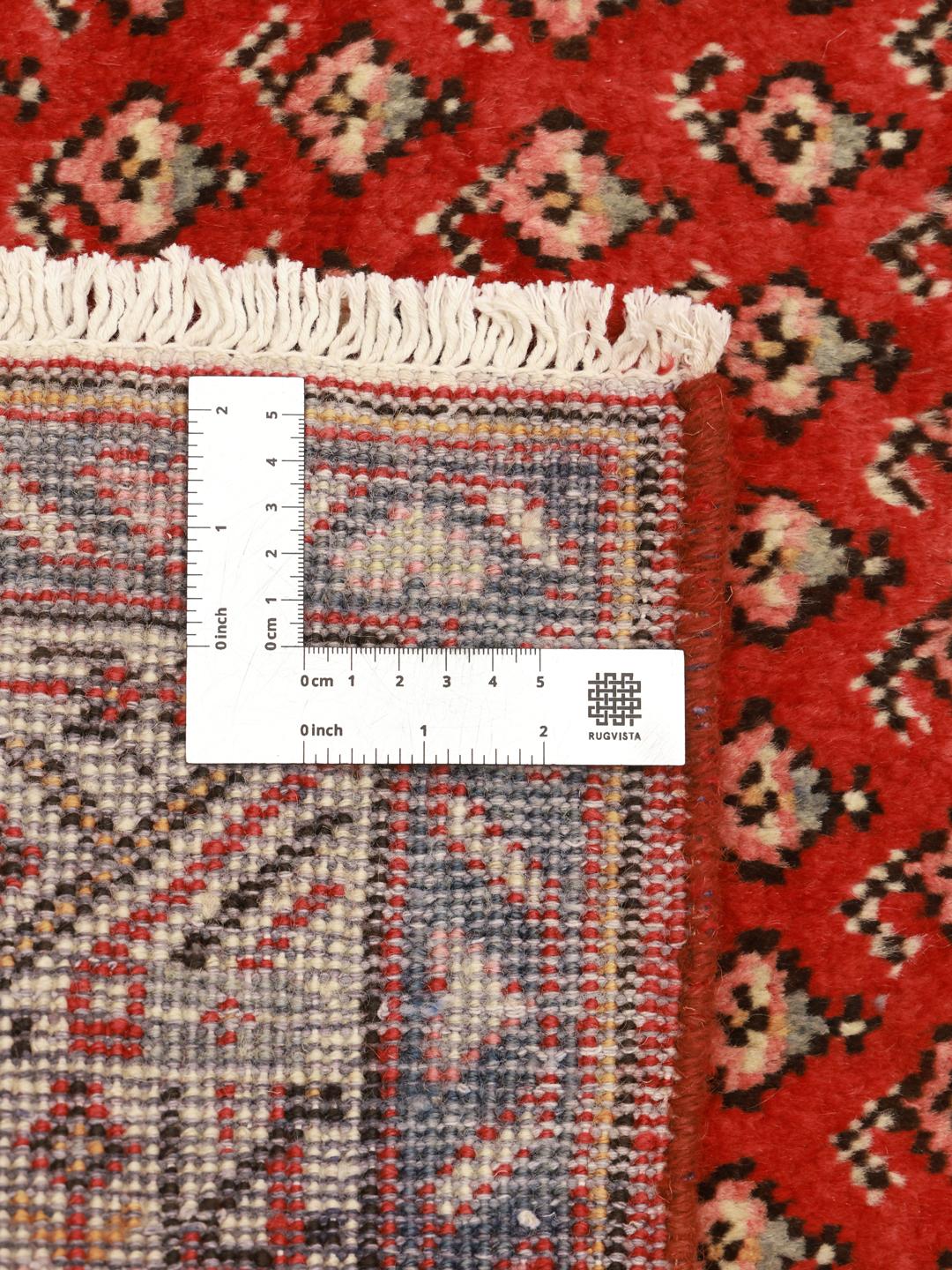 A hand-knotted red Hamadan runner with traditional geometric patterns from the Middle East