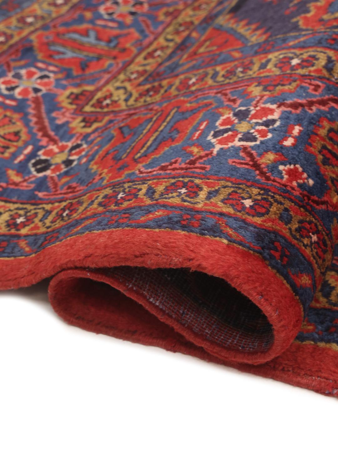 Een handgeknoopt Wiss tapijt uit het Midden-Oosten met een levendig rood en blauw geometrisch patroon.