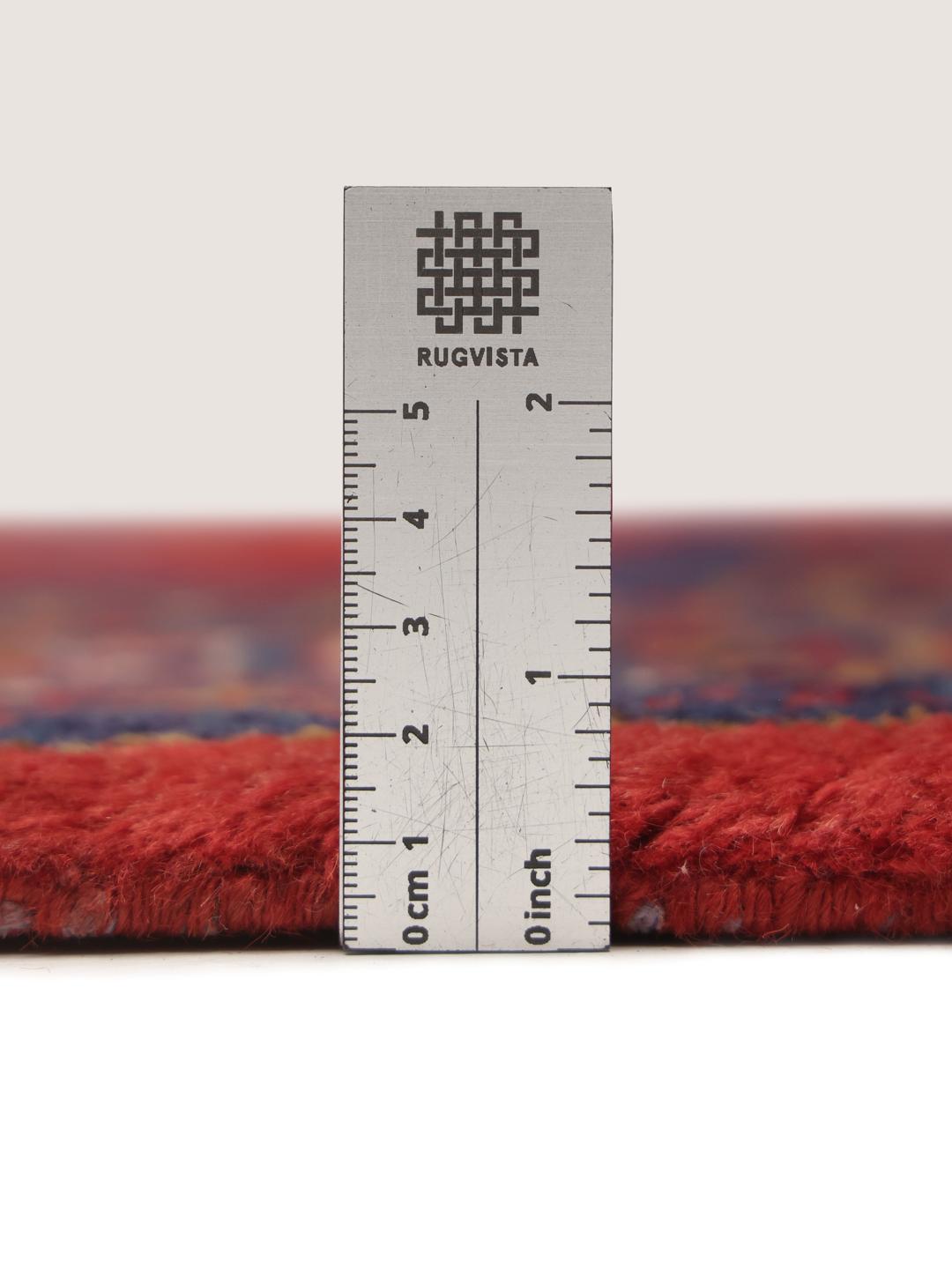 Een handgeknoopt Wiss tapijt uit het Midden-Oosten met een levendig rood en blauw geometrisch patroon.