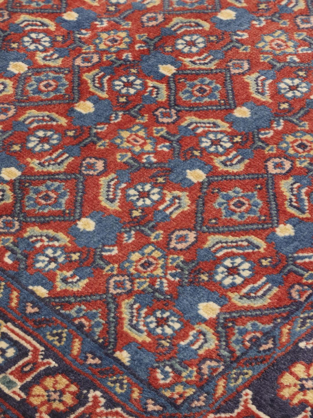 A hand-knotted Hamadan rug from the Middle East featuring blue and red tones.