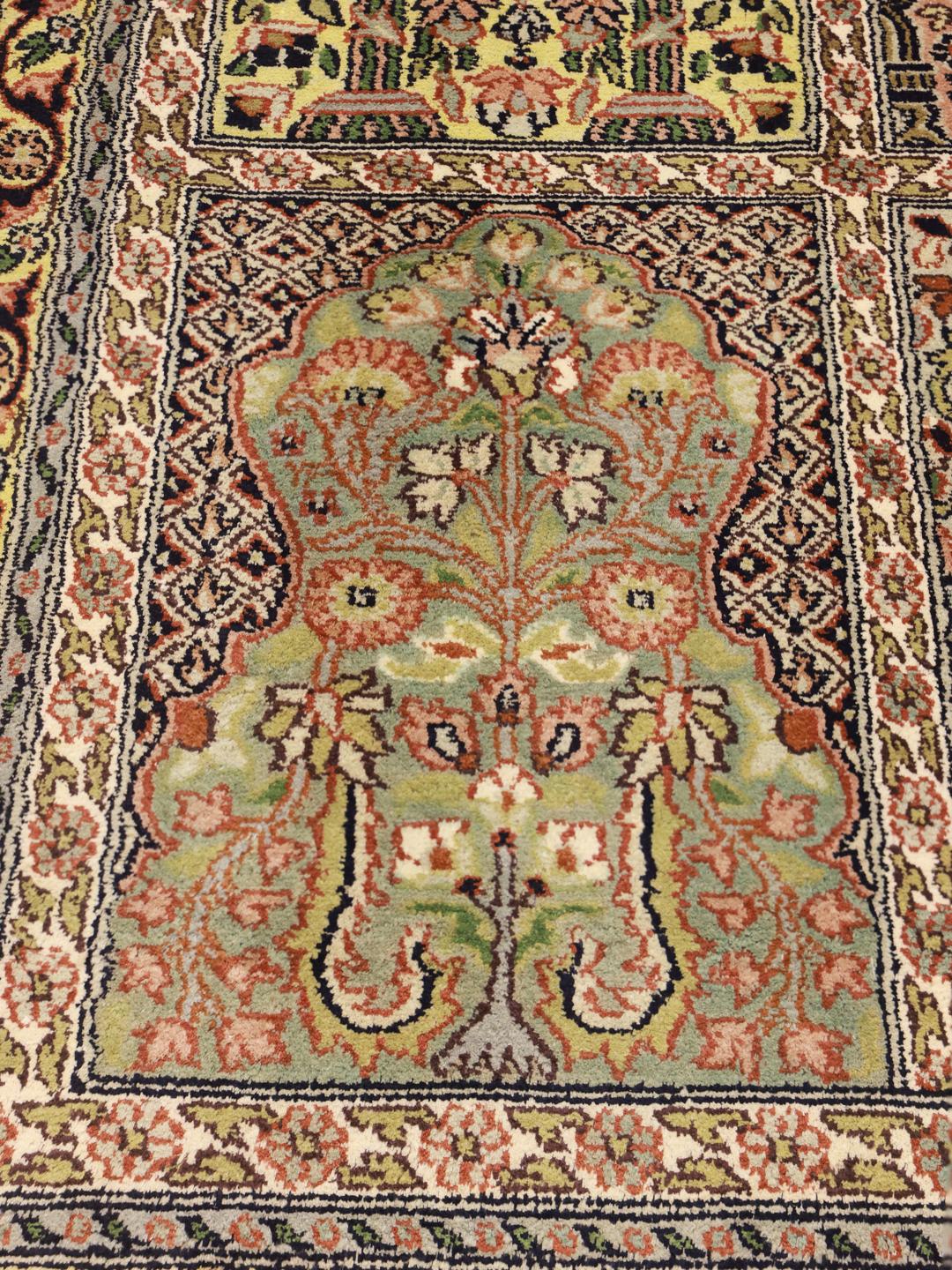 Et rektangulært Kashmir-silketæppe fra Indien med et beige og flerfarvet blomsterdesign.