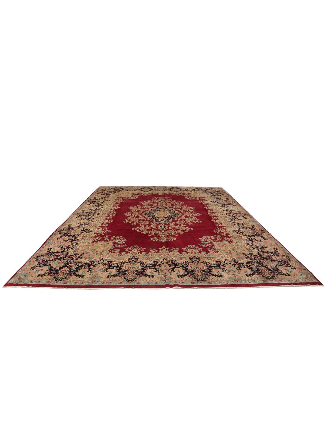 A hand-knotted Kerman rug from the Middle East with a dark-red field and floral patterns.