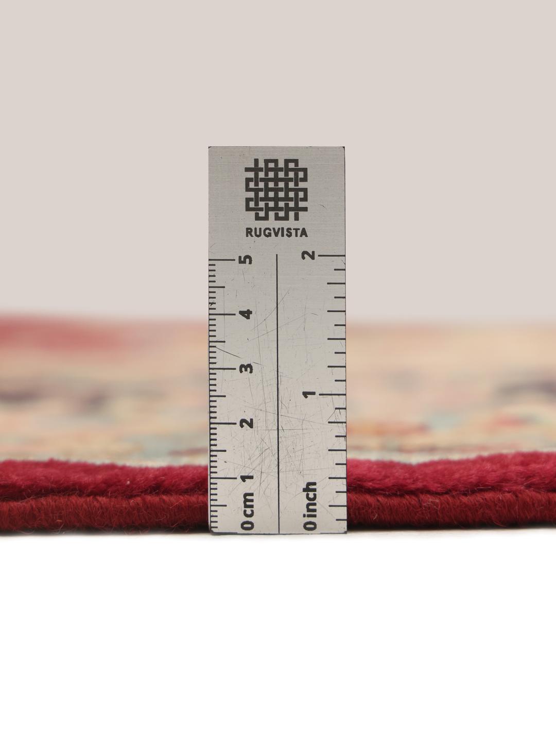 A hand-knotted Kerman rug from the Middle East with a dark-red field and floral patterns.