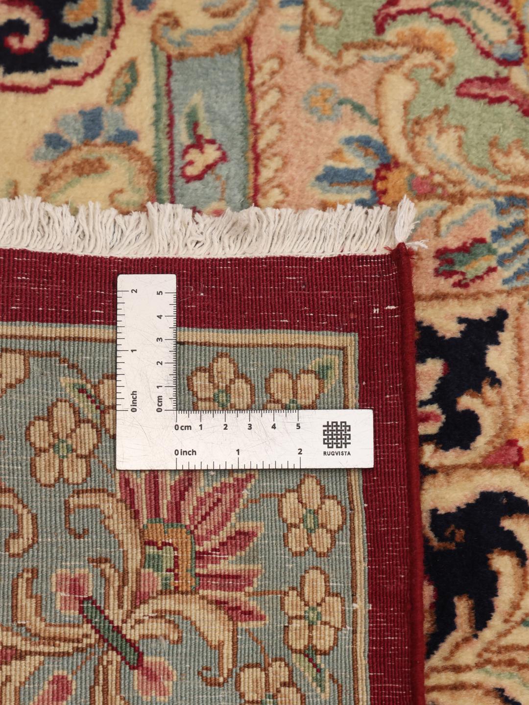 A hand-knotted Kerman rug from the Middle East with a dark-red field and floral patterns.
