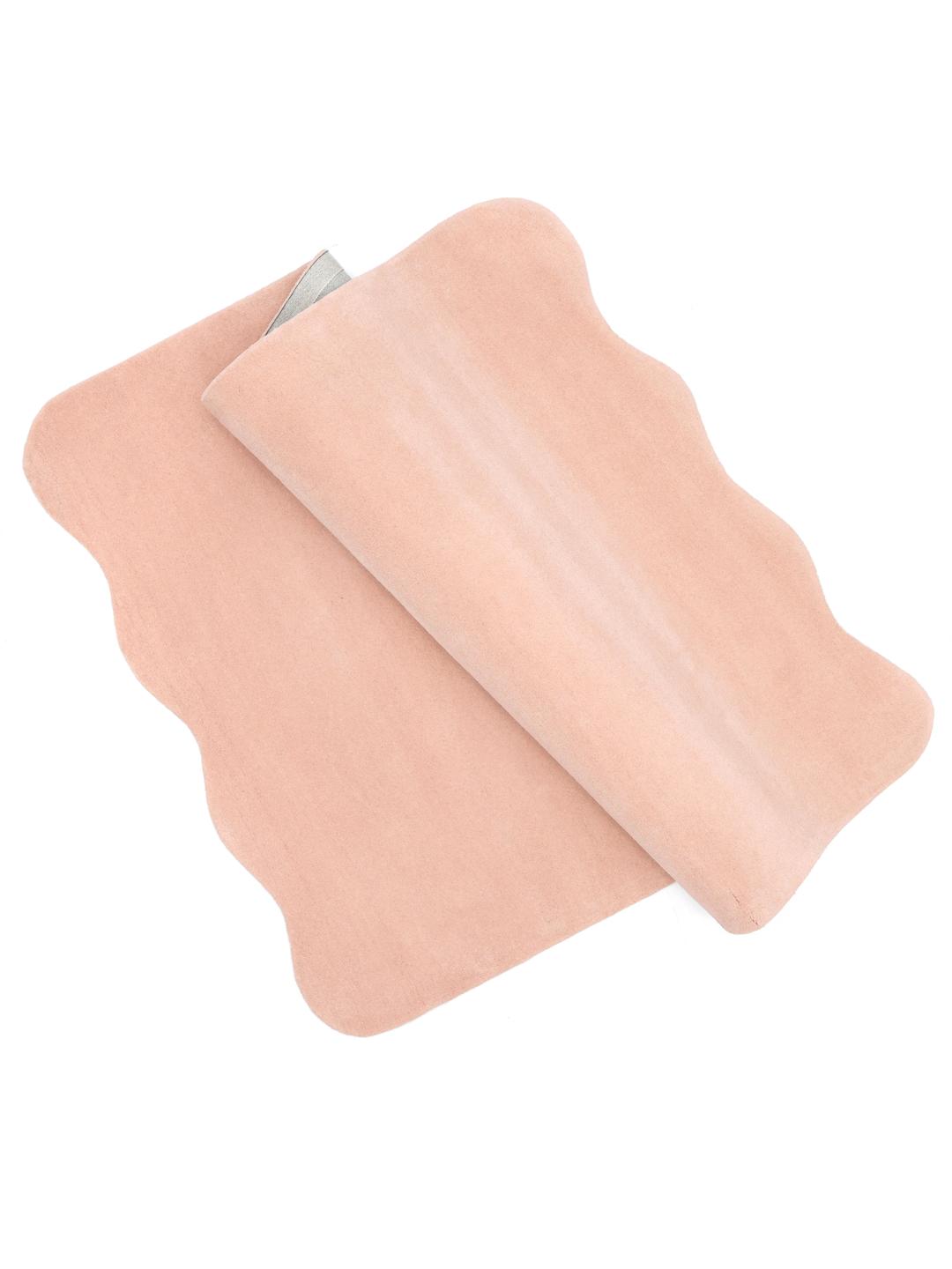 Een zacht roze vloerkleed met een onregelmatige geschulpte vorm