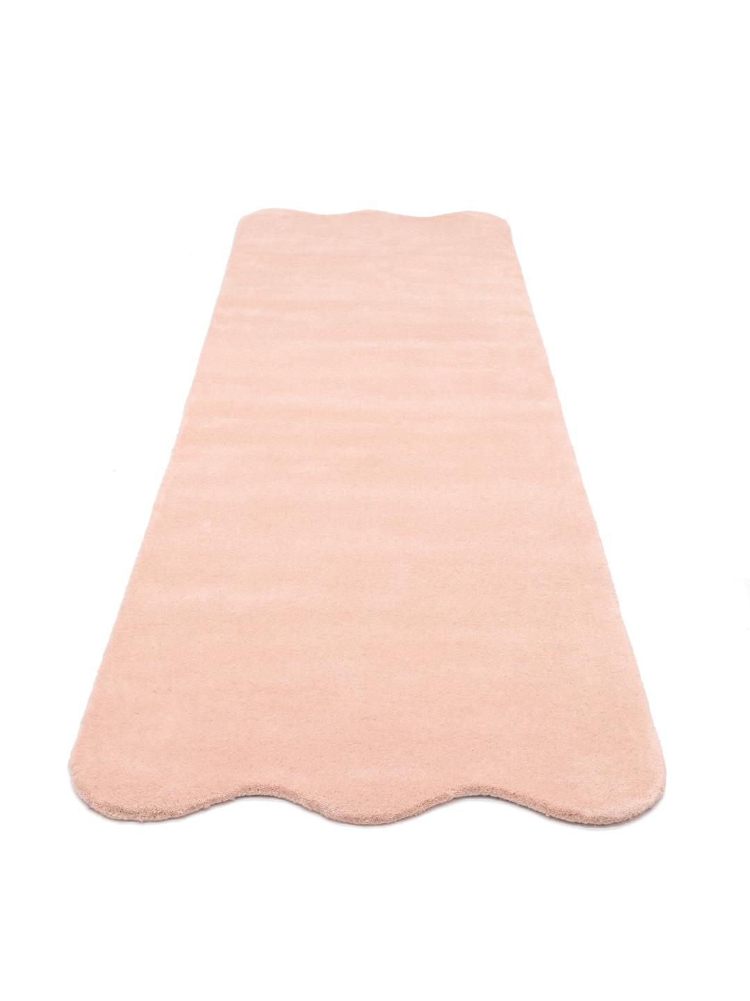 En blød pink uldløber med bølgede kanter