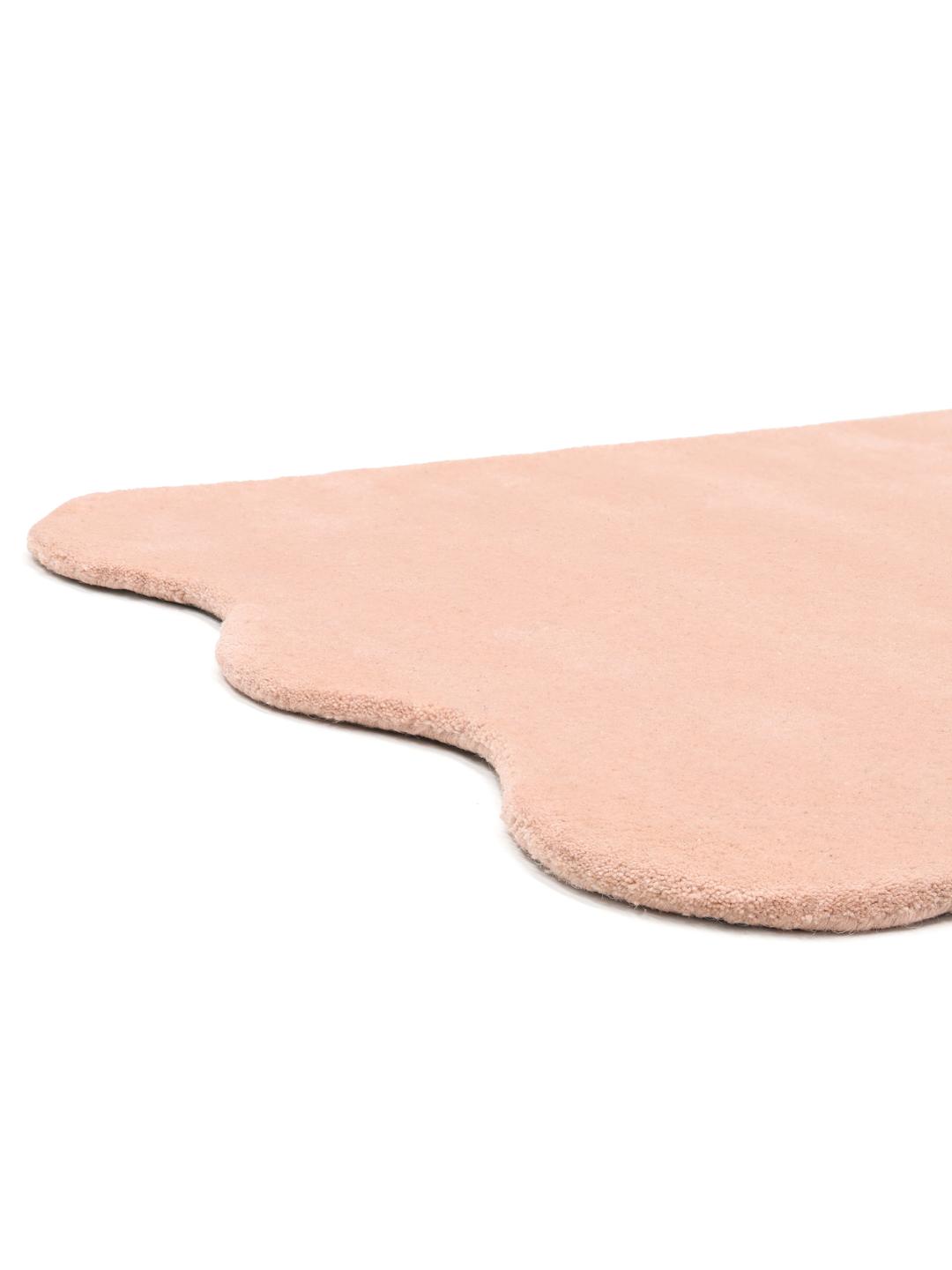 En blød pink uldløber med bølgede kanter