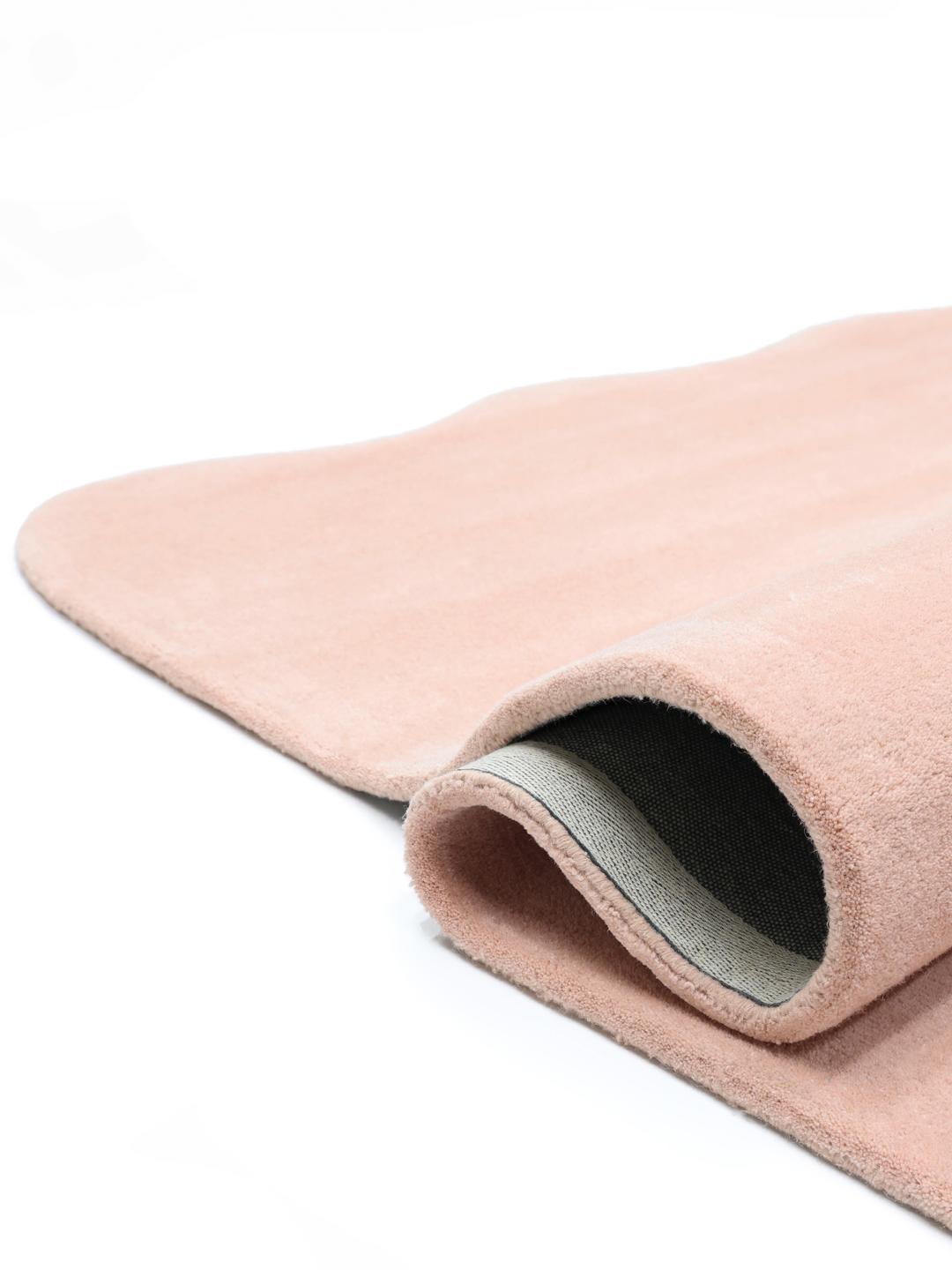 En blød pink uldløber med bølgede kanter