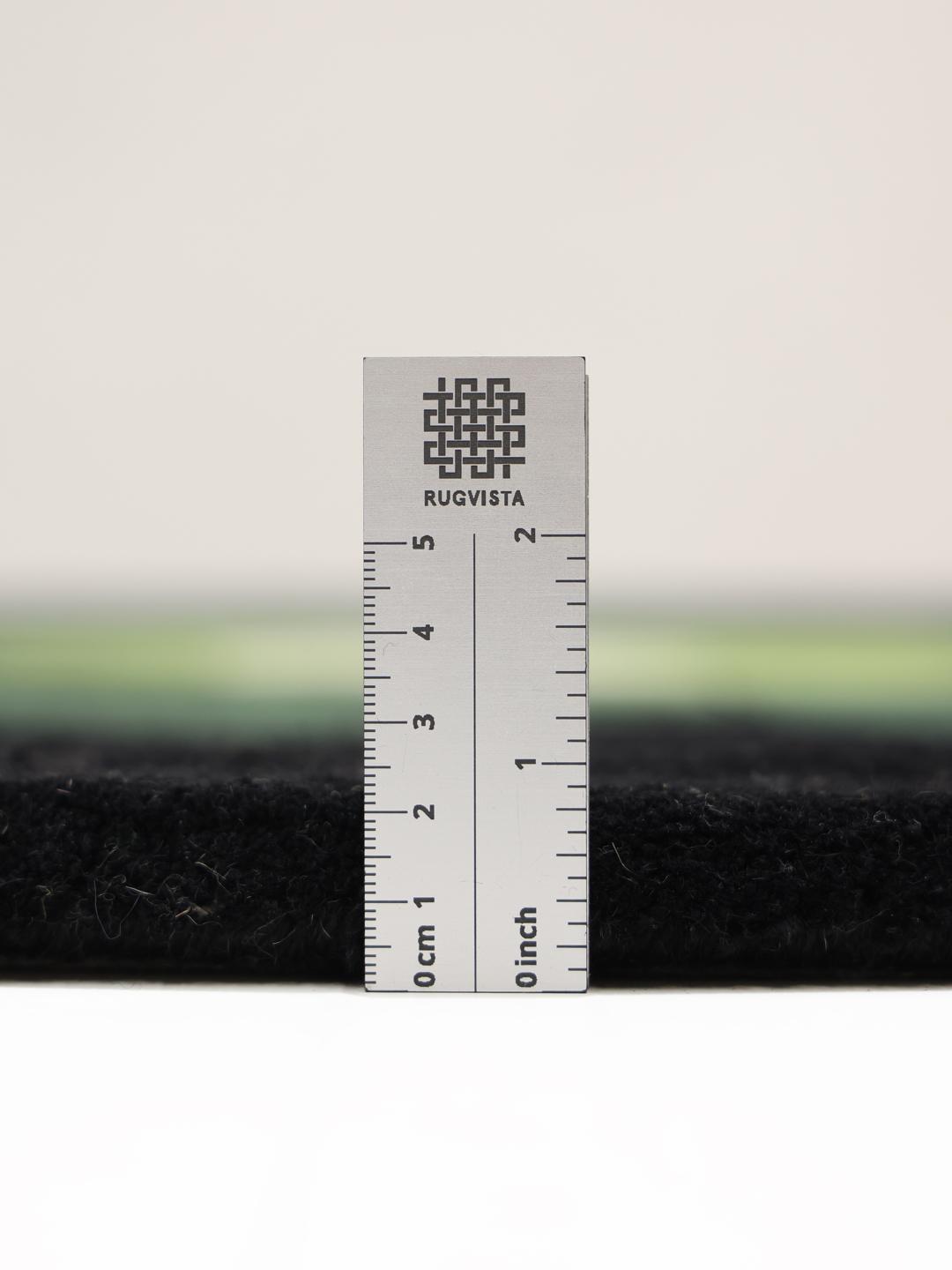Rond zwart en groen handgetuft vloerkleed met een patroon van concentrische cirkels.