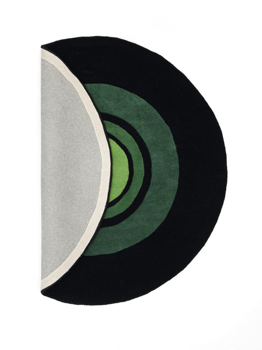 Rond zwart en groen handgetuft vloerkleed met een patroon van concentrische cirkels.