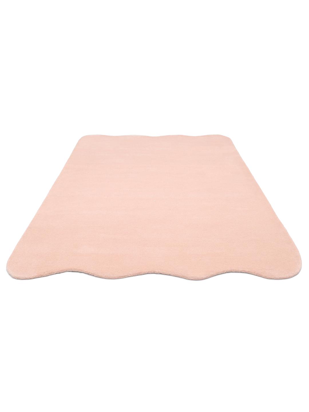 Een zacht roze vloerkleed met een onregelmatige geschulpte vorm