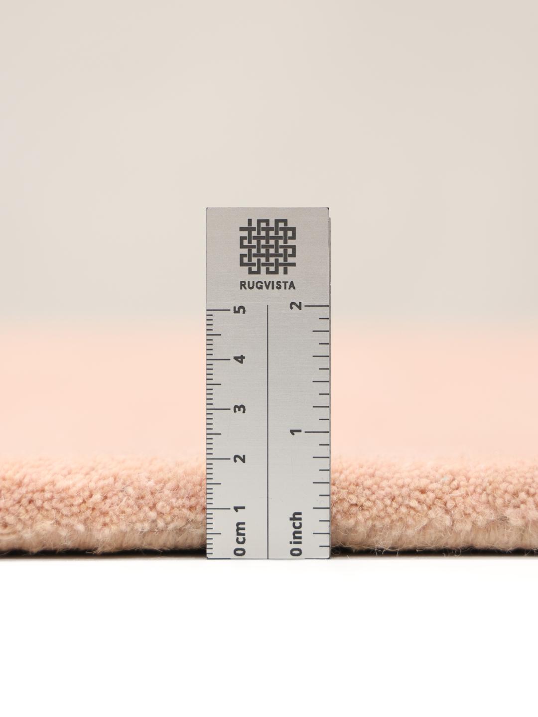 Een zacht roze vloerkleed met een onregelmatige geschulpte vorm
