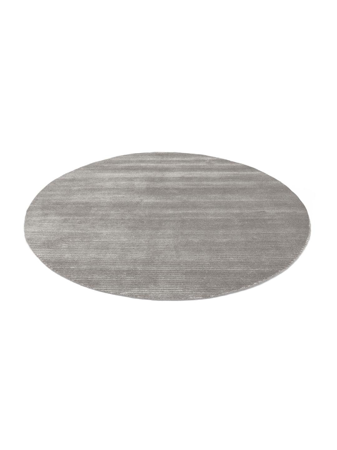 Un tapis rond gris avec un motif rayé subtil.